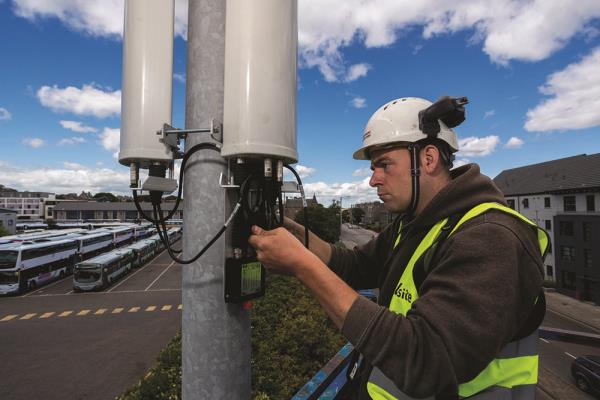 An engineer installs a small cell radio for O2 on a lamppost in Aberdeen.